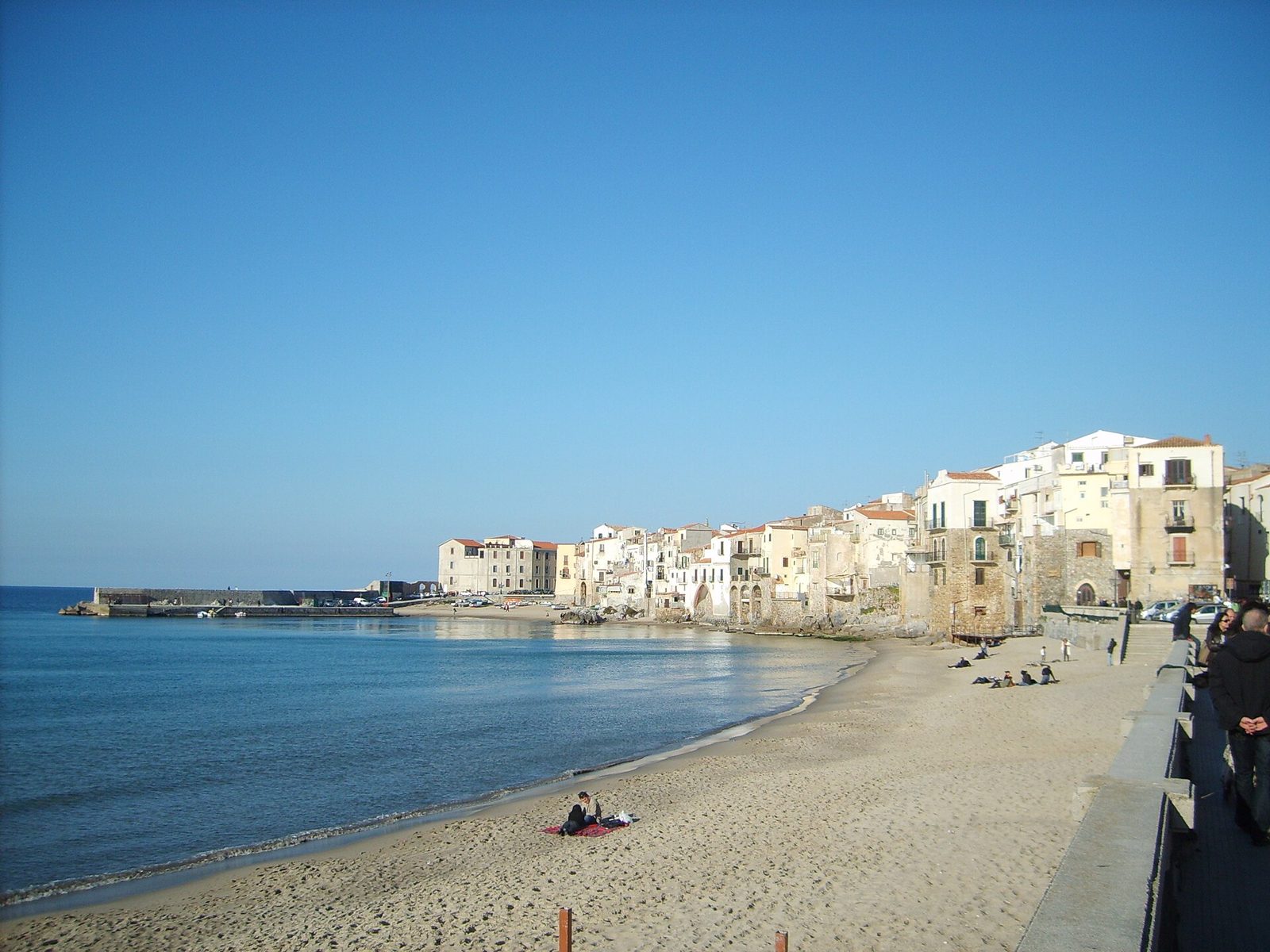 La spiaggia di Cefalù, sabbia dorata e mare con la Rocca sullo sfondo