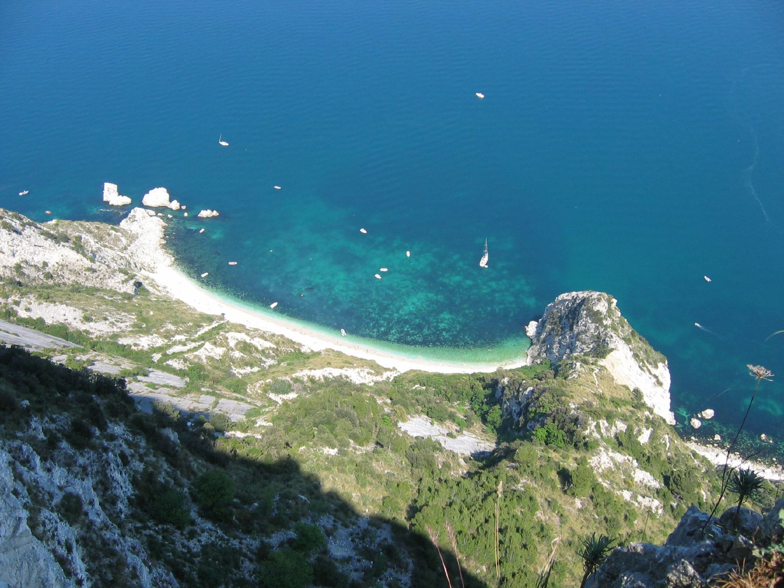 La falesia bianca del Monte Conero a picco sul mare turchese, con la spiaggia di ciottoli delle Due Sorelle